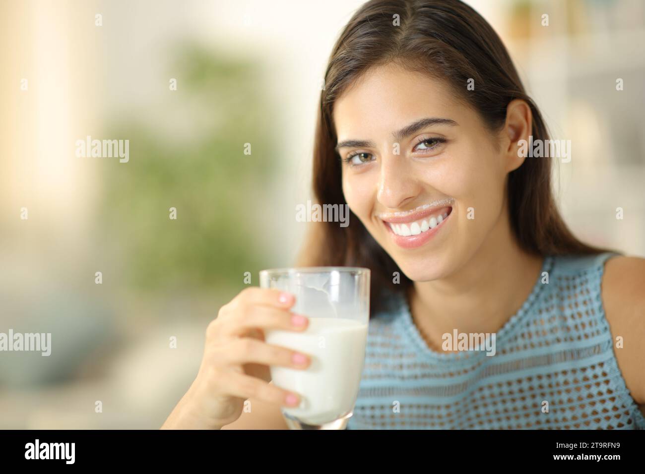 Happpy hembra bebiendo leche con labios sucios en casa Foto de stock