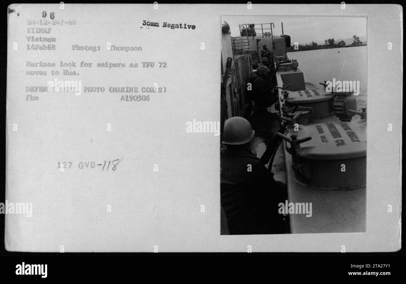Infantes de marina que llevan a cabo operaciones de combate durante la Operación Ciudad Hue en Vietnam el 14 de febrero de 1968. Están buscando francotiradores mientras YFU 72 se traslada a Hua. Esta fotografía fue tomada por Thompson y es un negativo de 35 mm. Es una foto del Departamento de Defensa cortesía del Cuerpo de Marines. Foto de stock