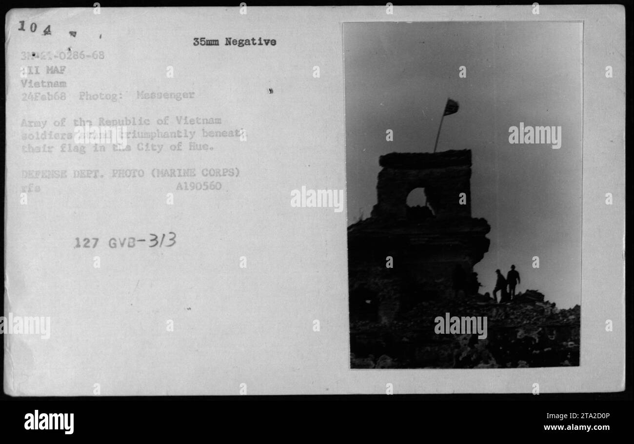 Soldados de ARVN mostrando la victoria bajo su bandera en la ciudad de Hue durante la batalla de Hue el 24 de febrero de 1968. Fotografiado por Messenger, un A190560 127 GVB-3/3 35mm negativo que documenta las actividades militares estadounidenses durante la Guerra de Vietnam. Foto de stock