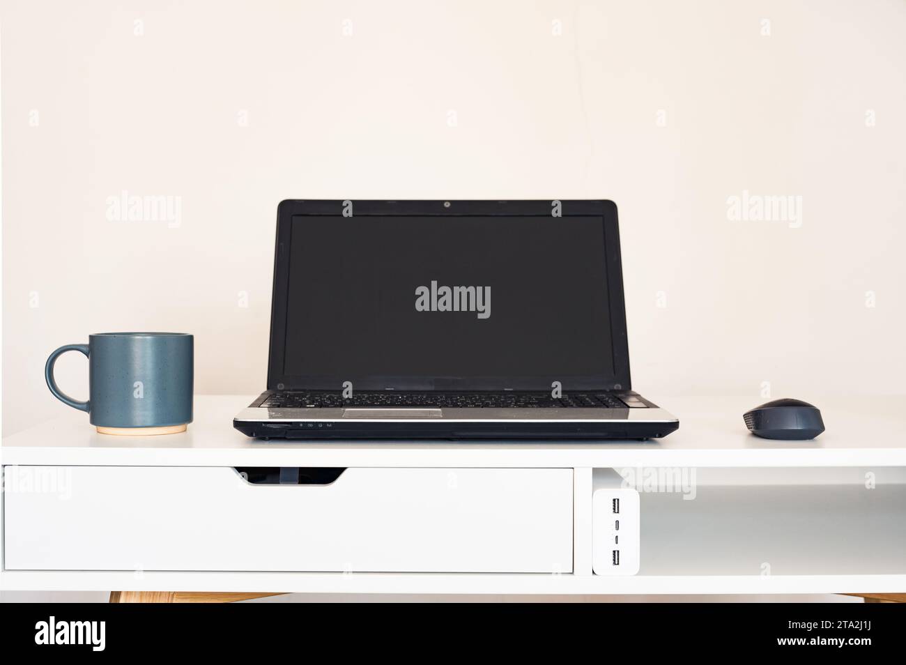 Escritorio del espacio de trabajo con ordenador portátil con pantalla en  blanco y taza de café, cuaderno con papel de documento en la mesa de la  oficina.