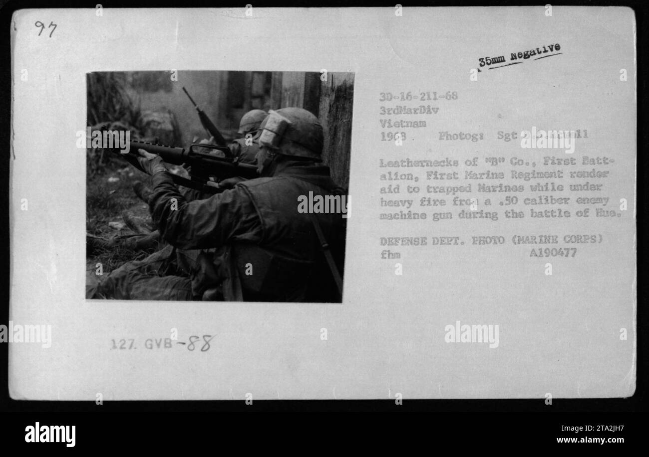 Infantes de Marina de la Compañía 'B', Primer Batallón, Primer Regimiento de Marines proporcionan ayuda a los infantes de marina atrapados mientras están bajo fuego pesado de una ametralladora anónima calibre .50 durante la batalla de Hue en Vietnam, 1968. (Fotografía tomada por el Sargento B.A. Atwell, 3ª División de Marines) Foto de stock