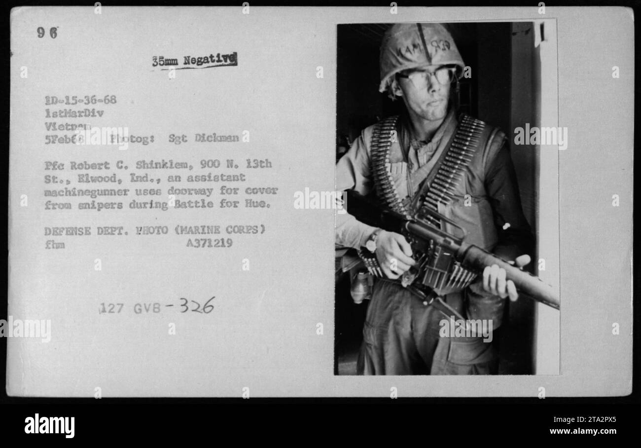 El infante de marina ESTADOUNIDENSE Robert C. Shinkiem de 1stMarDiv busca cobertura en una puerta para protegerse de los francotiradores durante la Batalla por Hue el 5 de febrero de 1968. Esta foto captura la intensidad y el peligro que enfrentaron los soldados durante la guerra de Vietnam. Los francotiradores eran una amenaza constante para las fuerzas militares estadounidenses. Foto de stock