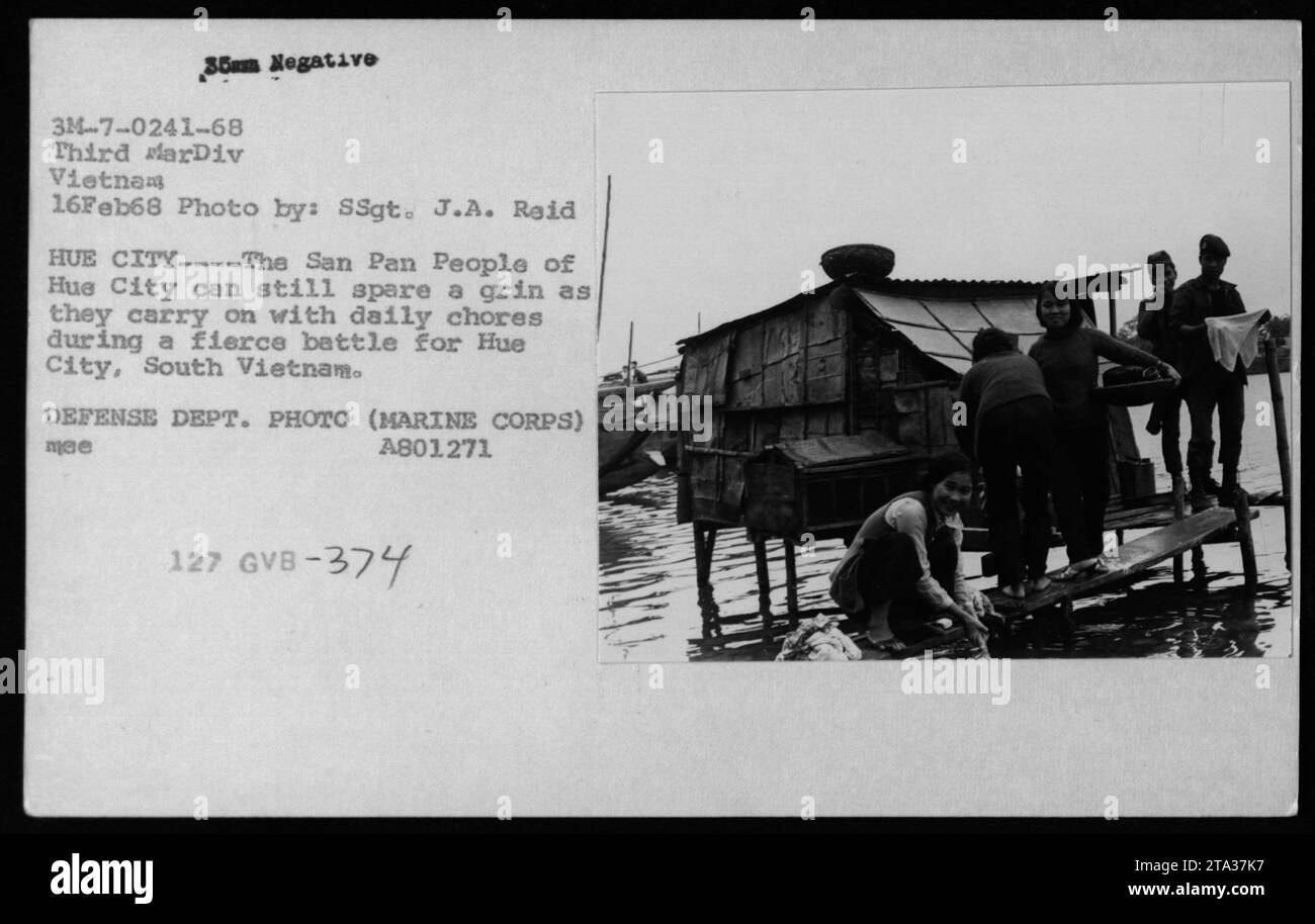 Los civiles vietnamitas en la ciudad de Hue continúan con sus actividades diarias en medio de intensos combates por el control de la ciudad durante la guerra de Vietnam. Foto del Departamento de Defensa tomada por SSgt. J.A. Reid el 16 de febrero de 1968. Foto de stock