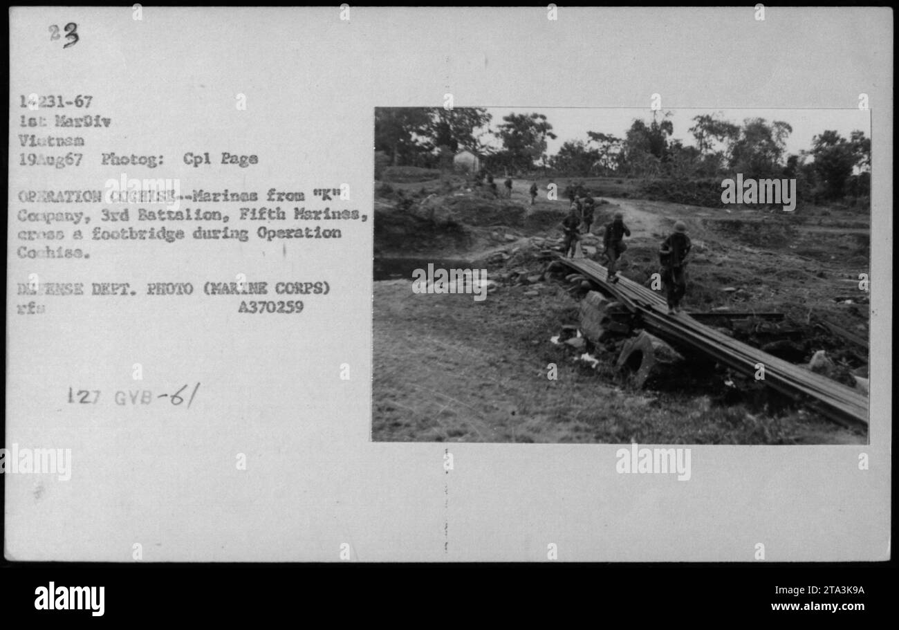 Infantes de marina de la Compañía 'K', 3er Batallón, Quinto Infantería de Marina, cruzan una pasarela durante la Operación Cochise. Esta foto fue tomada el 19 de agosto de 1967, como parte de las actividades militares de la Guerra de Vietnam. Foto de stock