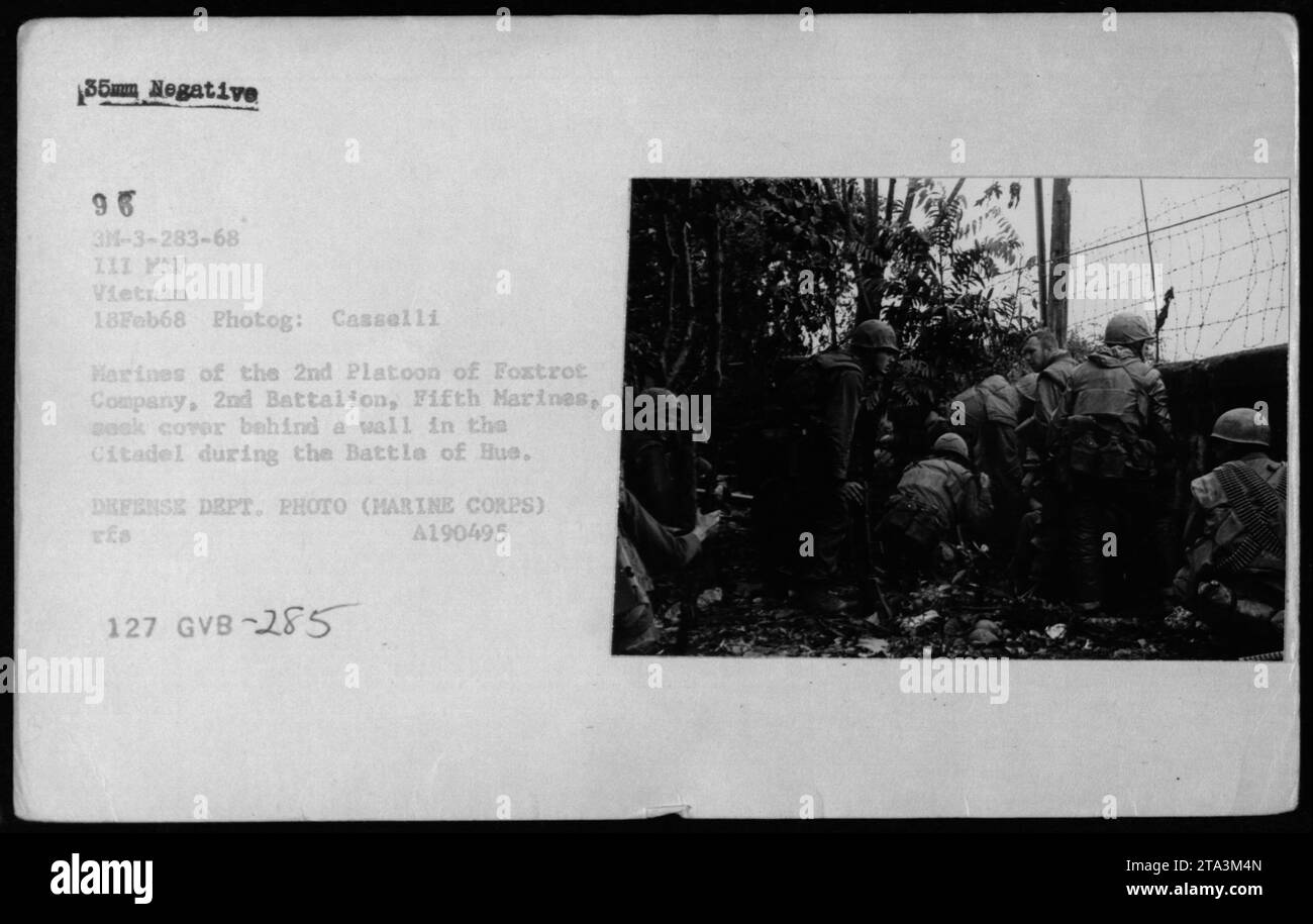 Los infantes de marina del 2º Batallón, el Quinto Infantería de Marina, se cubren detrás de una pared en la Ciudadela durante la Batalla de Huế. Esta fotografía fue tomada el 18 de febrero de 1968. Foto de stock
