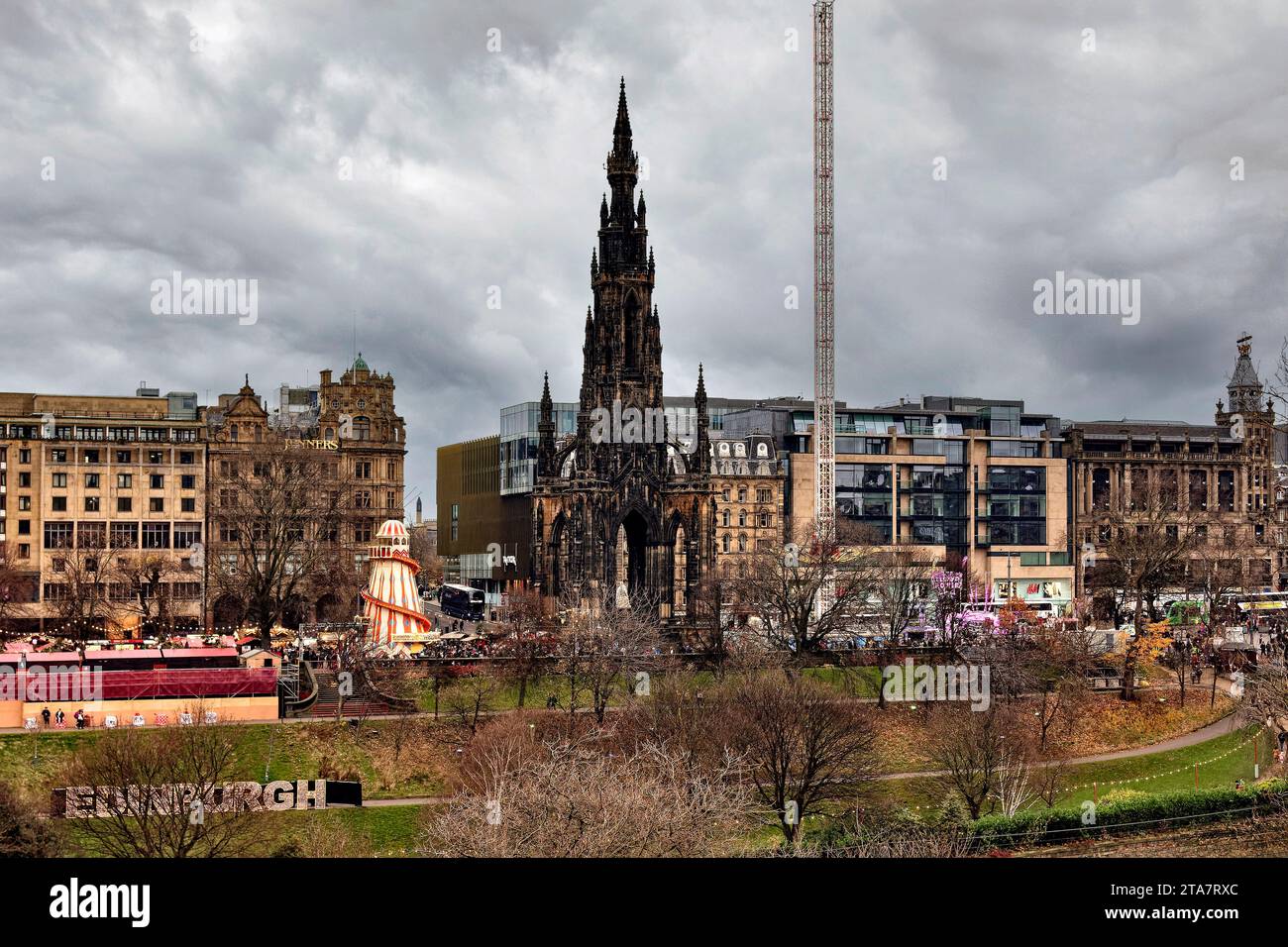 La Feria de Navidad de Edimburgo Escocia o el Mercado Princes Street pone puestos multitudes y la columna Star Flyer Foto de stock