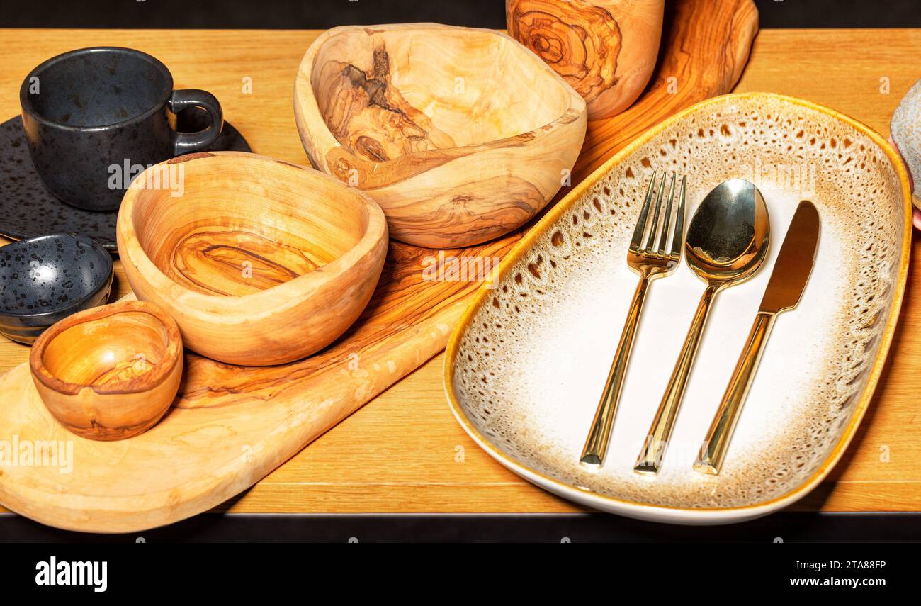 Hermosa cerámica, cuencos de madera hechos a mano, platos de cerámica vacíos y tazas en un soporte de madera. Foto de stock