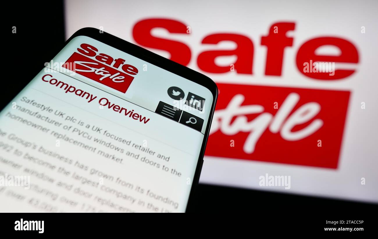 Teléfono móvil con sitio web de la empresa británica de ventanas Safestyle UK plc frente al logotipo del negocio. Enfoque en la parte superior izquierda de la pantalla del teléfono. Foto de stock