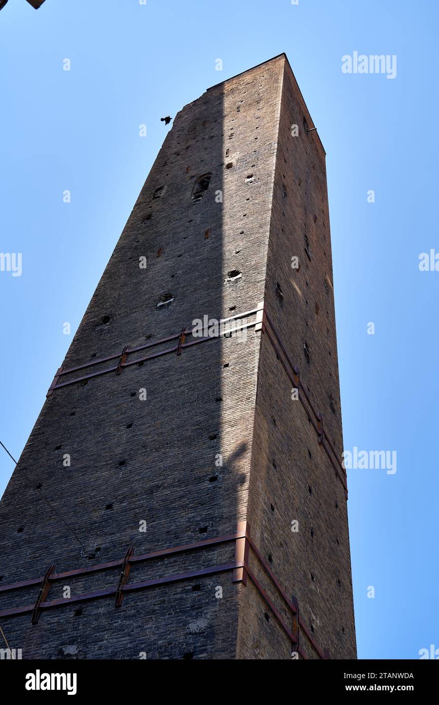 La Torre Garisenda Una de las dos torres inclinadas en Bolonia, las correas metálicas ayudan a mantener la integridad estructural Foto de stock