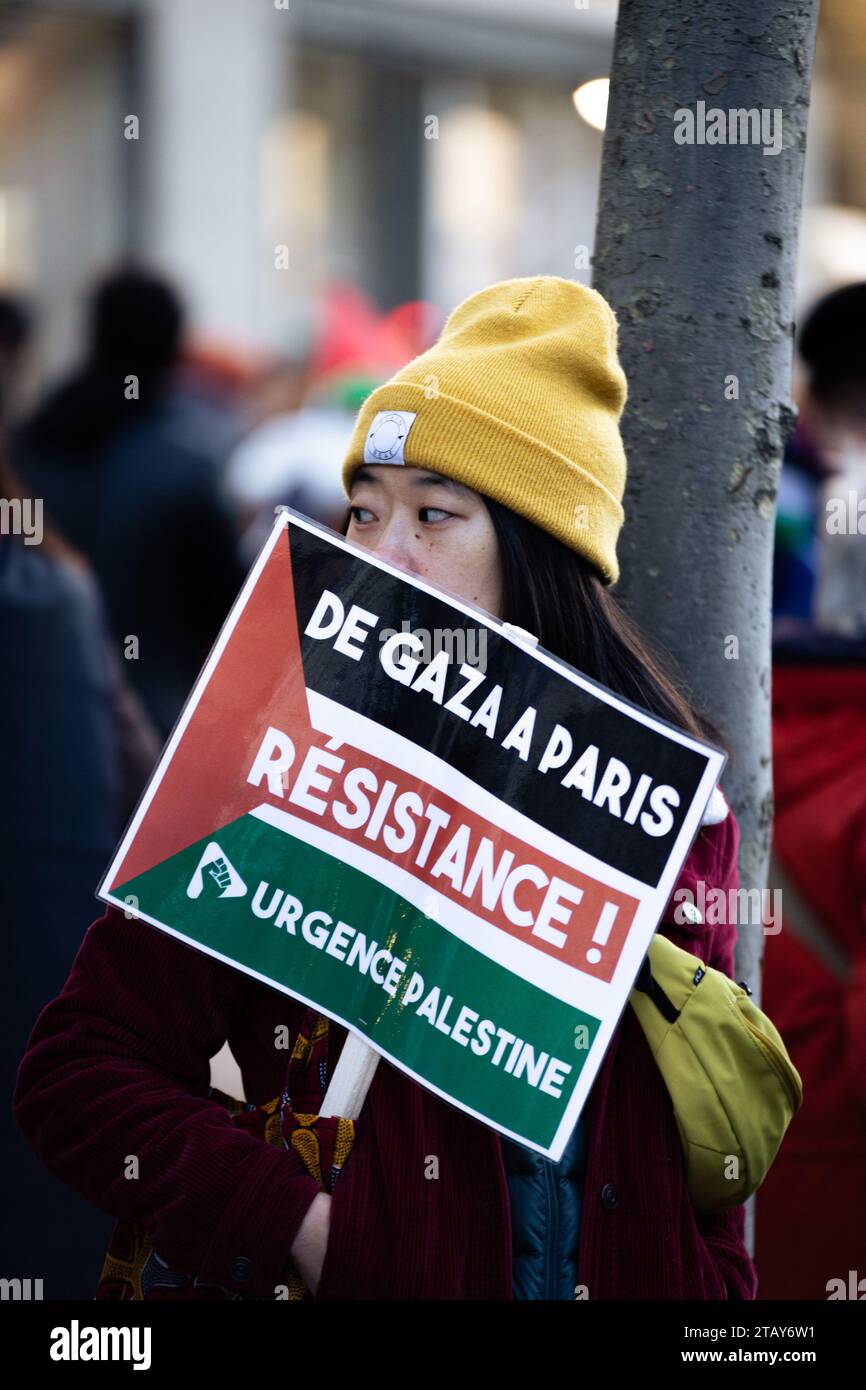 París, Francia. 2 de diciembre de 2023. Una mujer sostiene un cartel