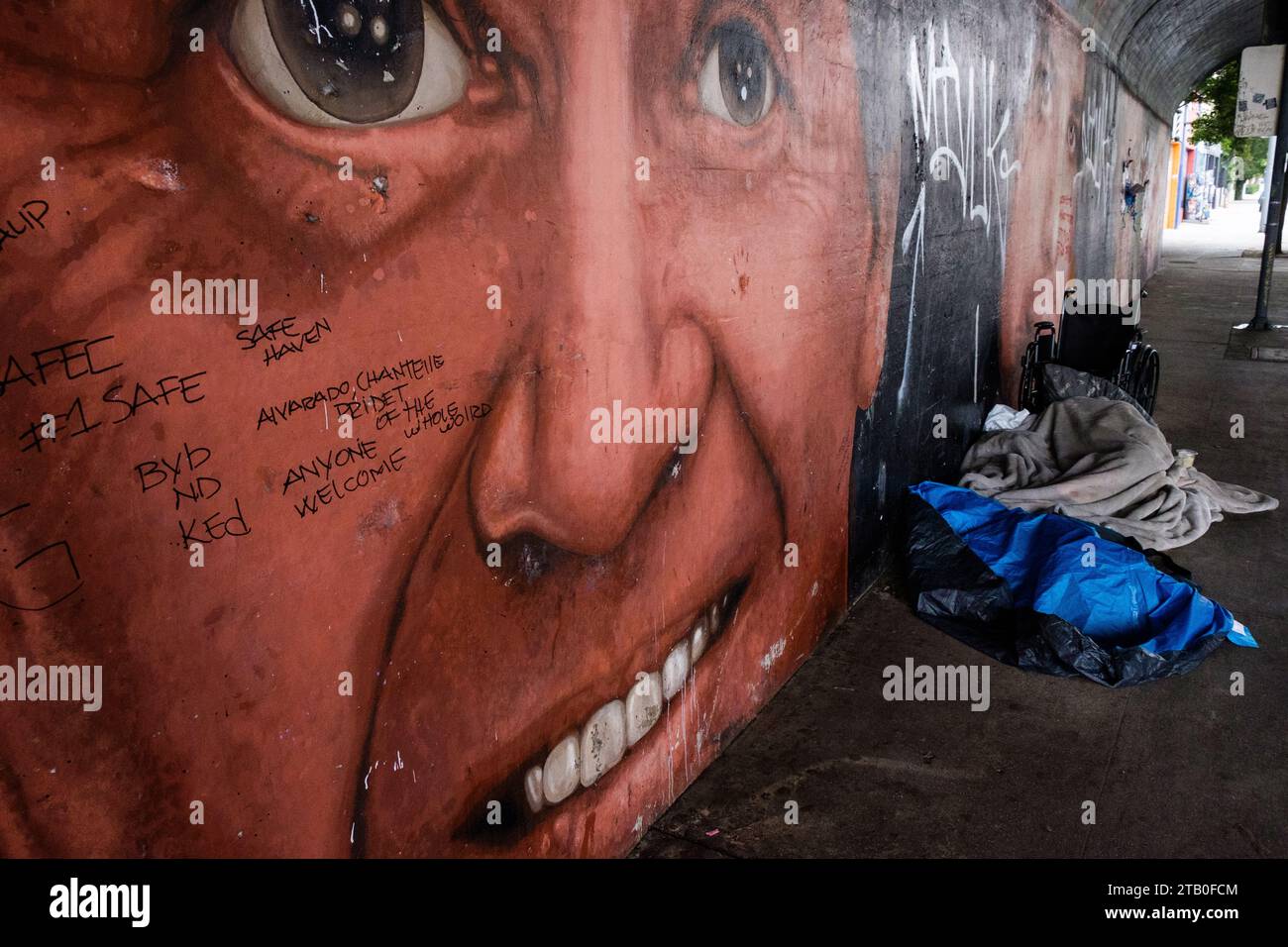 Equipo de personas sin hogar en s calle debajo de un mural en Los Ángeles, California, EE.UU. Foto de stock