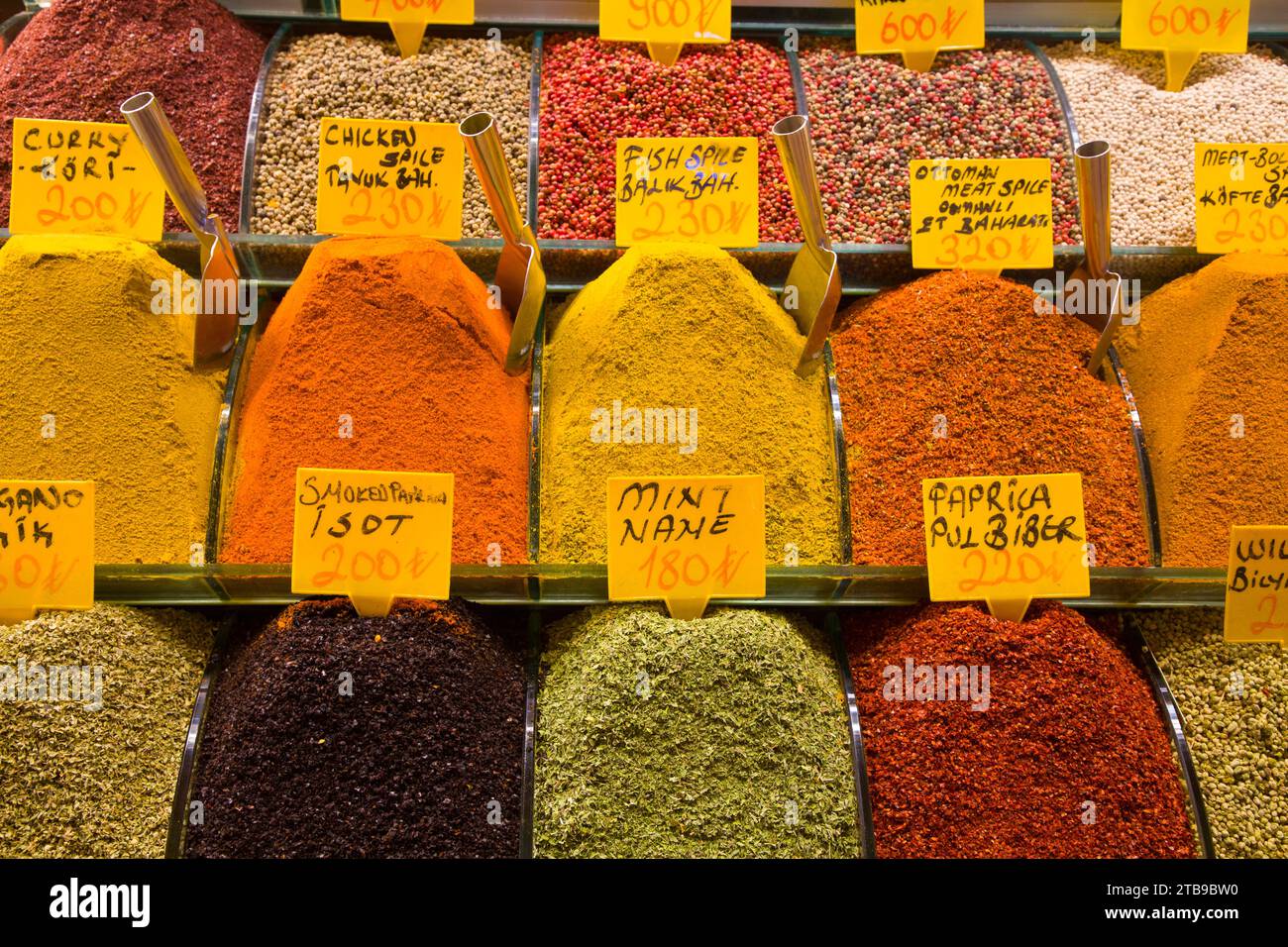 Coloridas especias para la venta, colmadas en contenedores de plástico con palas de metal en exhibición en una tienda en el Bazar de las Especias en el Distrito de Fatih; Estambul, Turquía Foto de stock