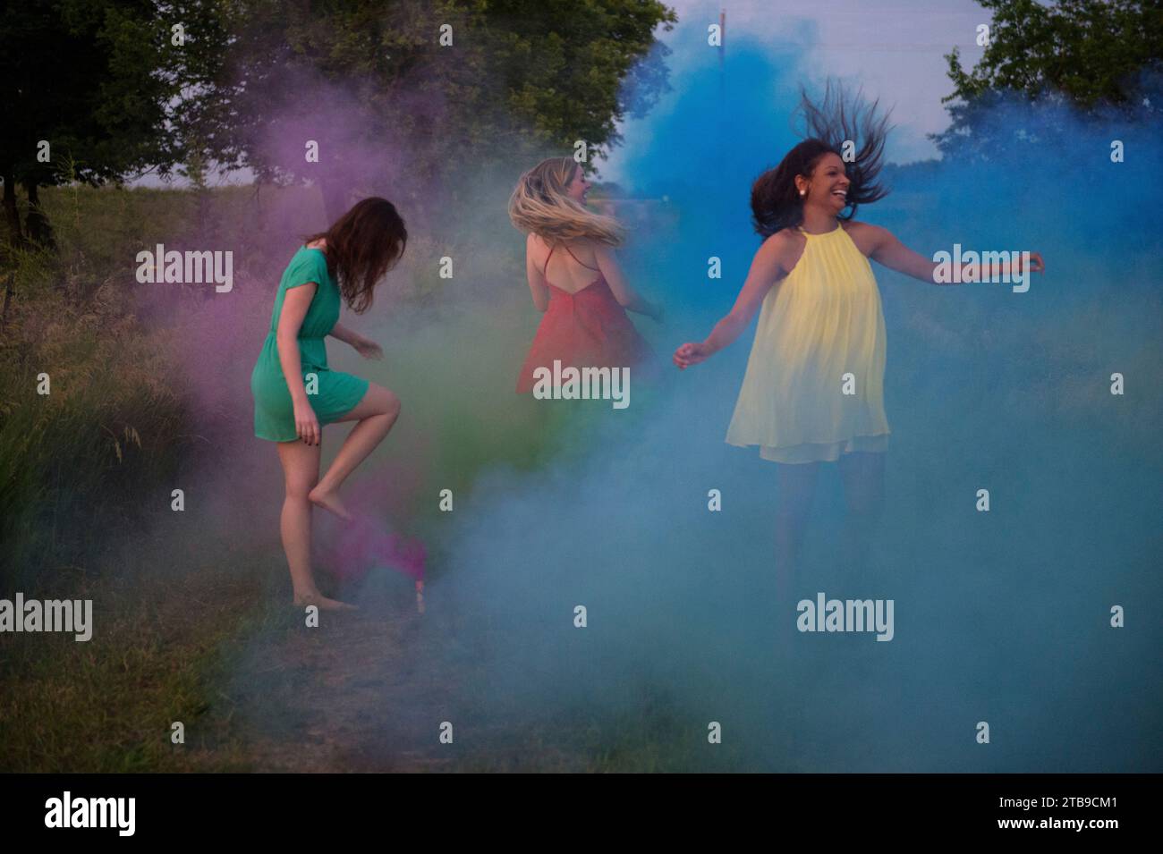 Tres mujeres jóvenes pasan por galletas de fuego con bombas de humo; Bennet, Nebraska (Estados Unidos de América) Foto de stock