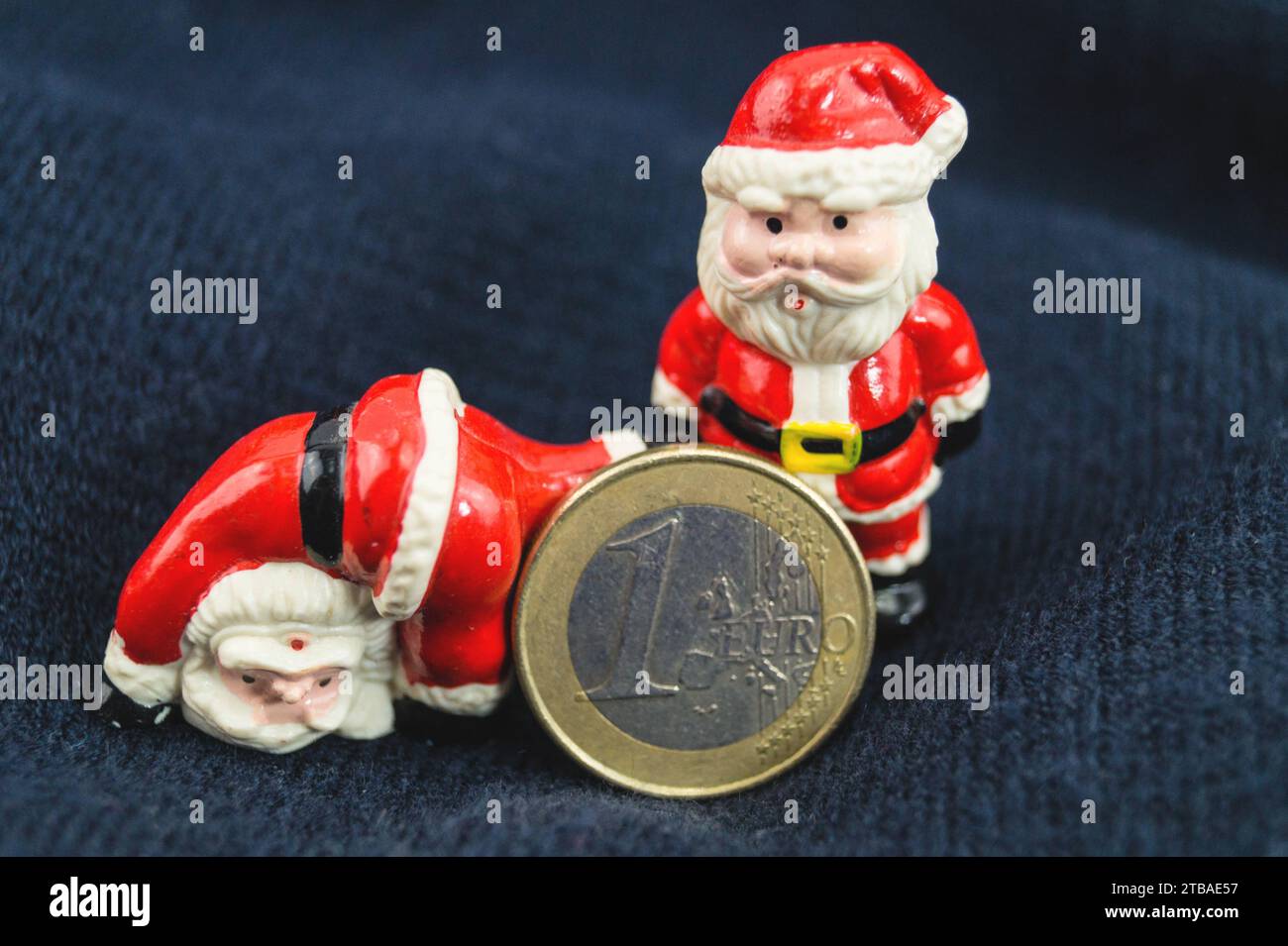 Dos cláusulas de Santa con moneda de euro, imagen de símbolo para la bonificación de fin de año Foto de stock