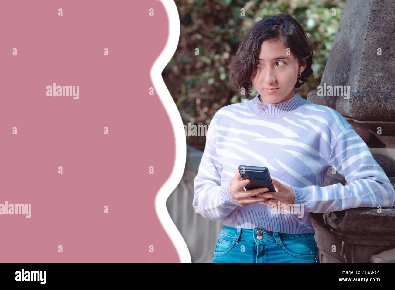 Foto creativa, una chica está de pie y mirando su teléfono celular, tiene expresión de incertidumbre, espacio libre para el texto, redes sociales. Foto de stock