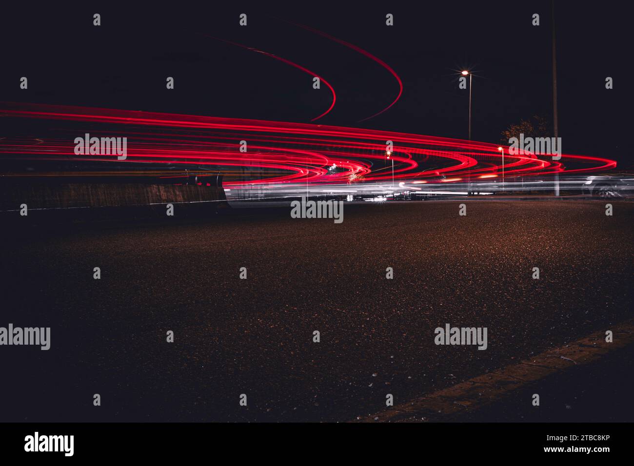 Rastros de luz de un coche por la noche en un círculo de tráfico de la ciudad Foto de stock