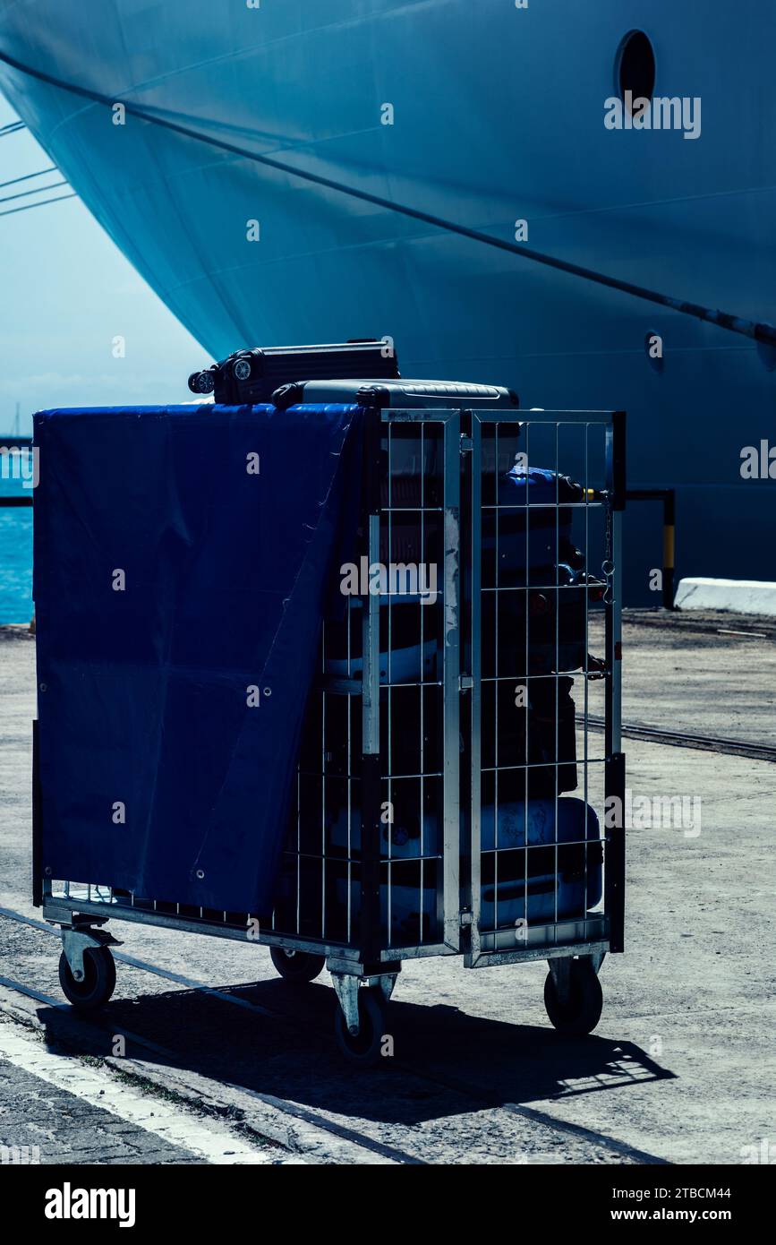 Un carrito conveniente para transportar equipaje junto a un crucero atracado Foto de stock