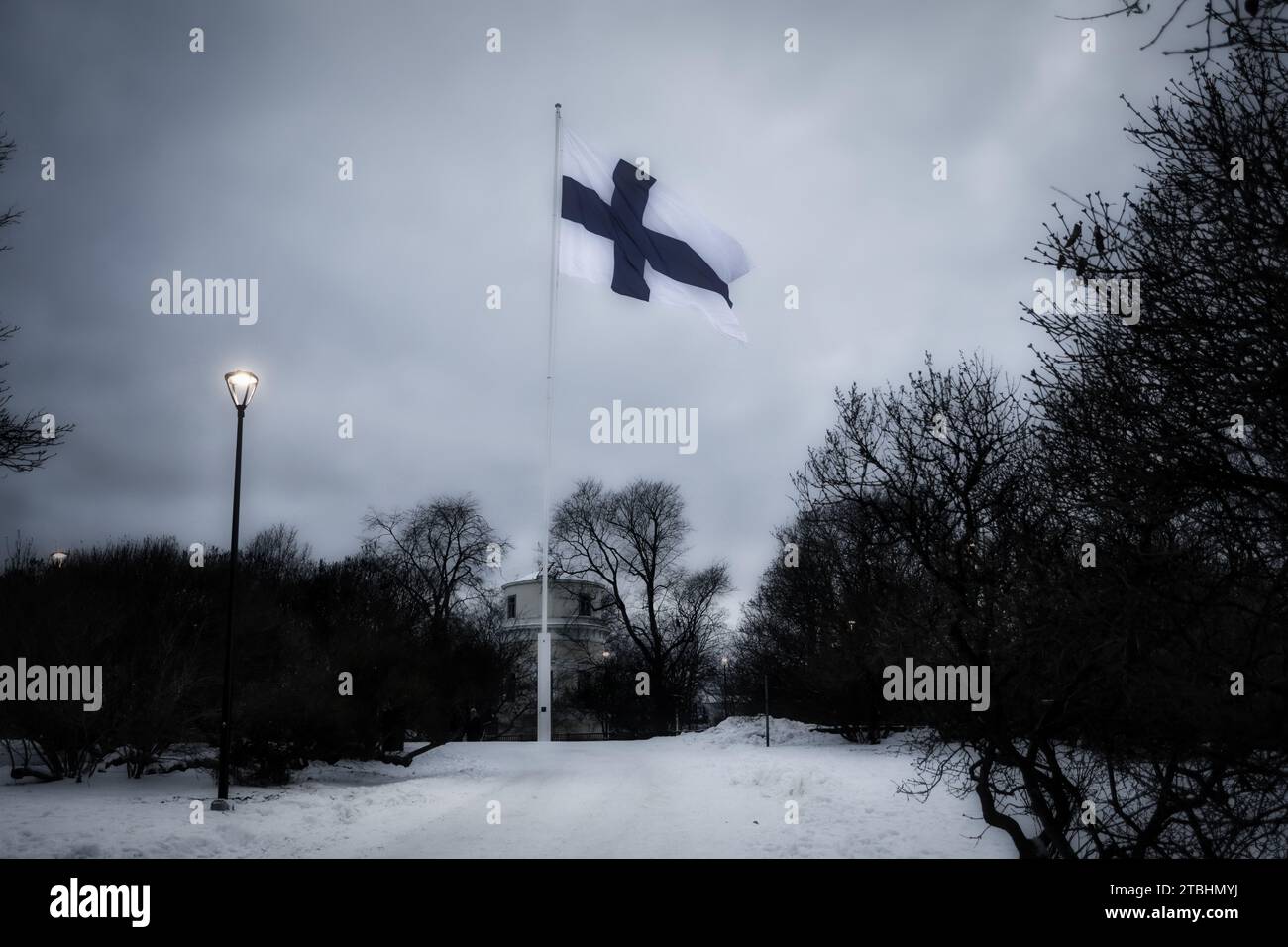 Bandera de Finlandia en Tähtitorninmäki o Observatorio Hill, Helsinki, Finlandia en el día 106 de la independencia de Finlandia al caer la noche. 6 de diciembre de 2023. Foto de stock