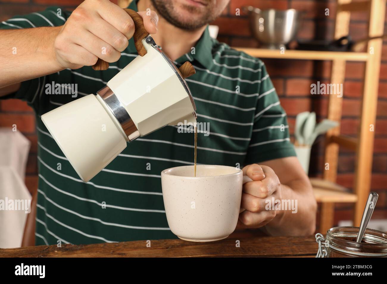 Verter el café de una cafetera eléctrica italiana, rodada en low key.  Vierta el café negro macho de manos de la italiana moka brewer Fotografía  de stock - Alamy