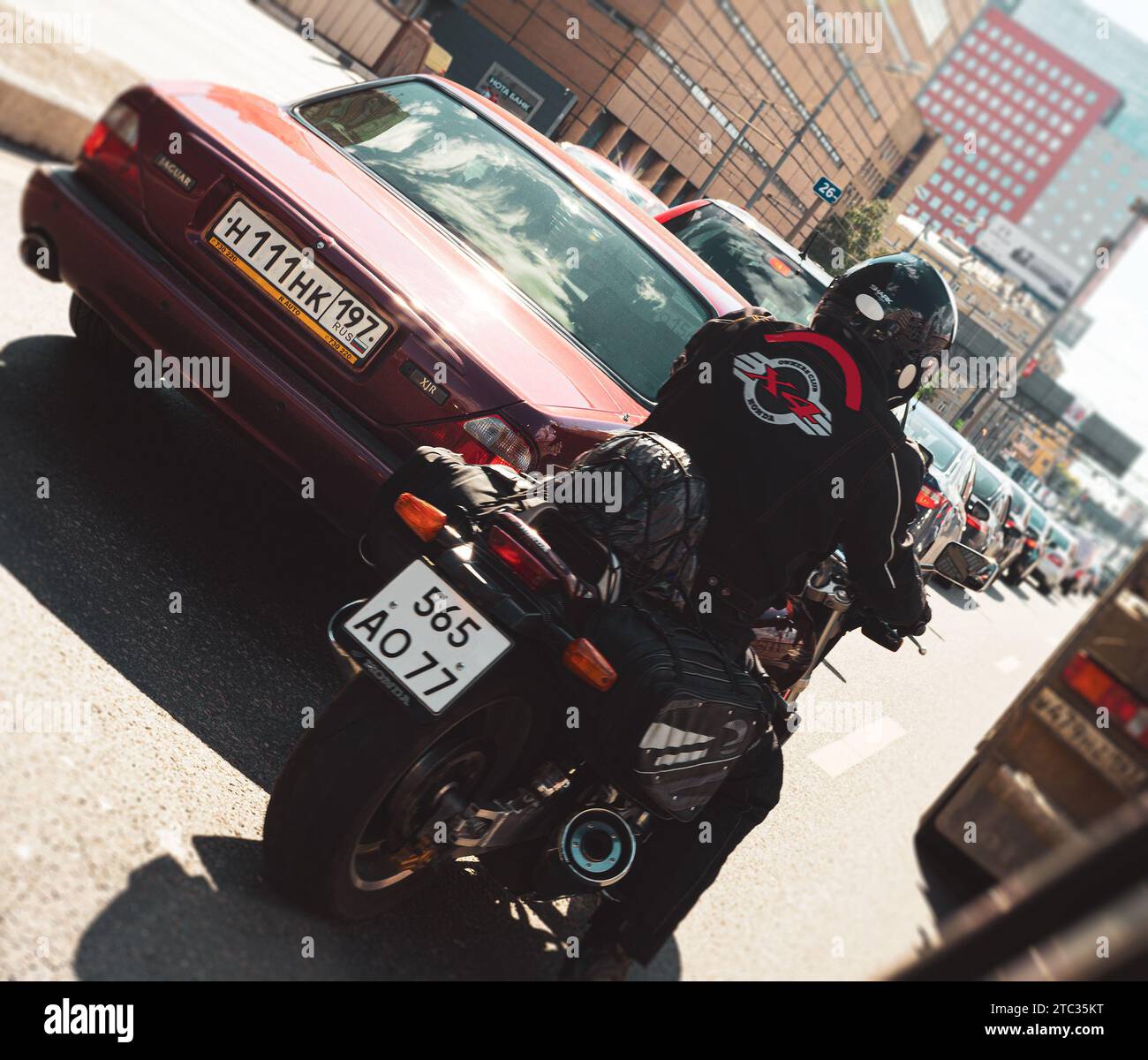 Motociclista conduce una moto deportiva Honda entre el tráfico atascado de la carretera de la ciudad Foto de stock