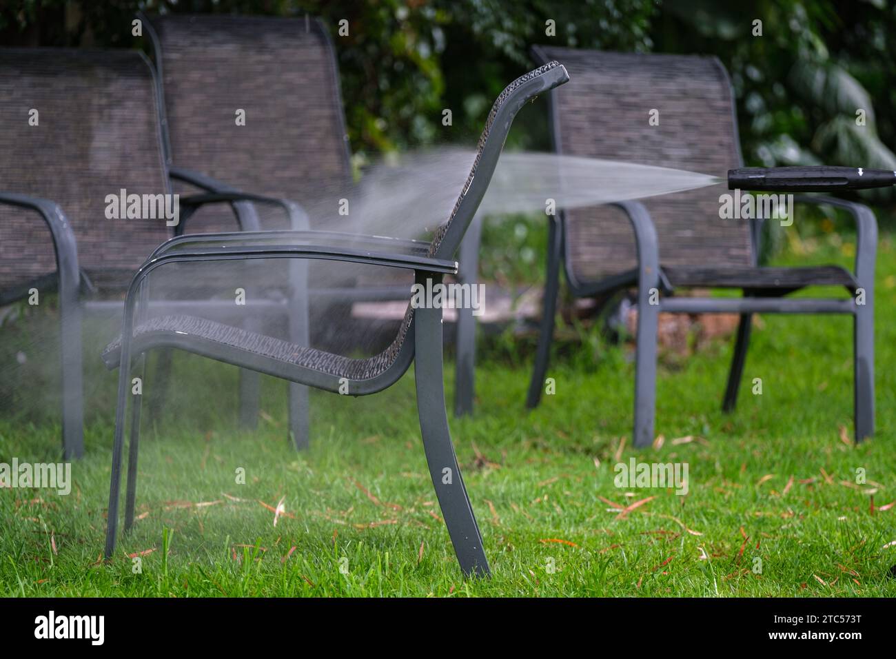 Limpieza de muebles de exterior con un chorro de agua Foto de stock