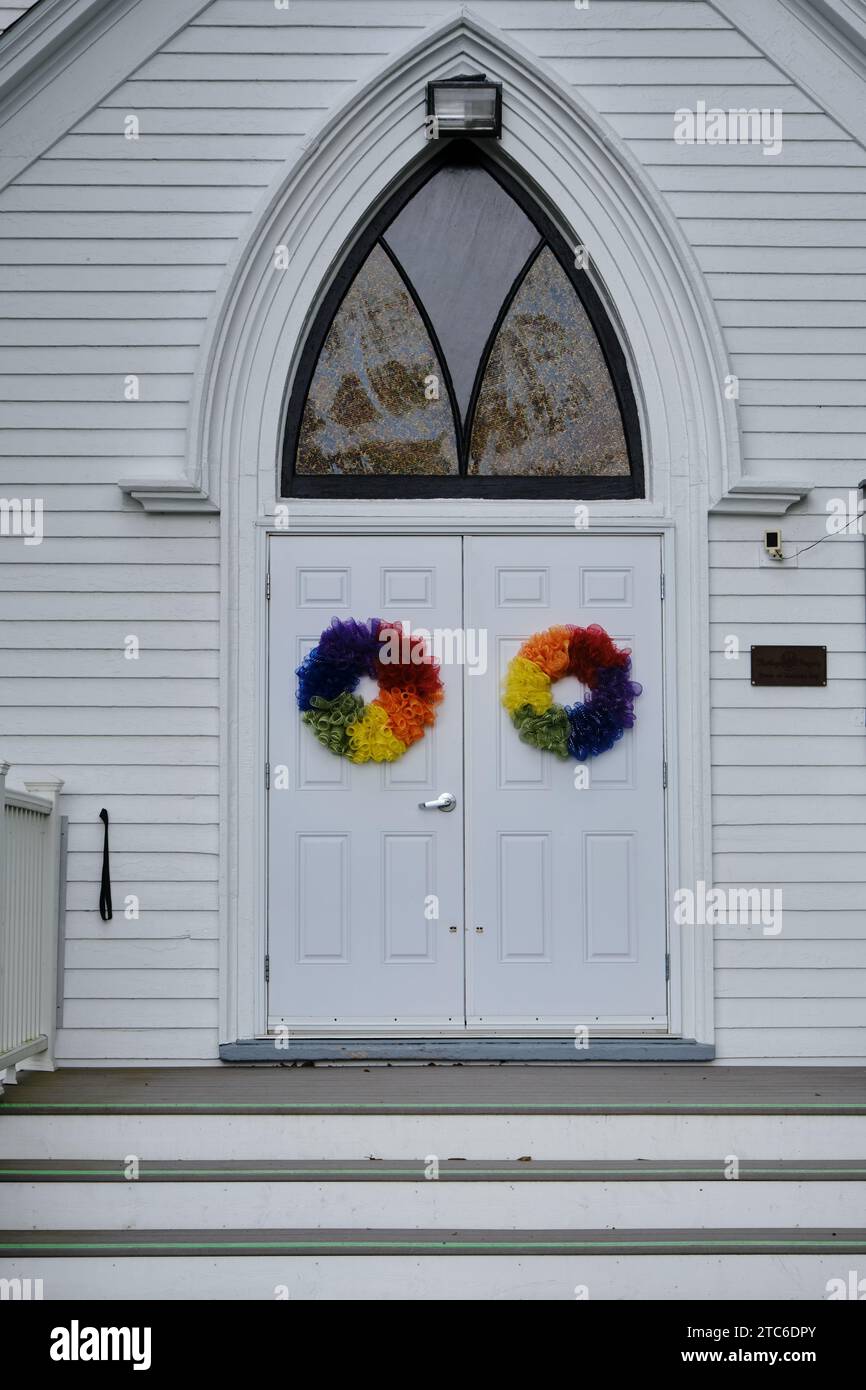 puerta de la iglesia con guirnaldas en color arco iris de aceptación del orgullo Foto de stock