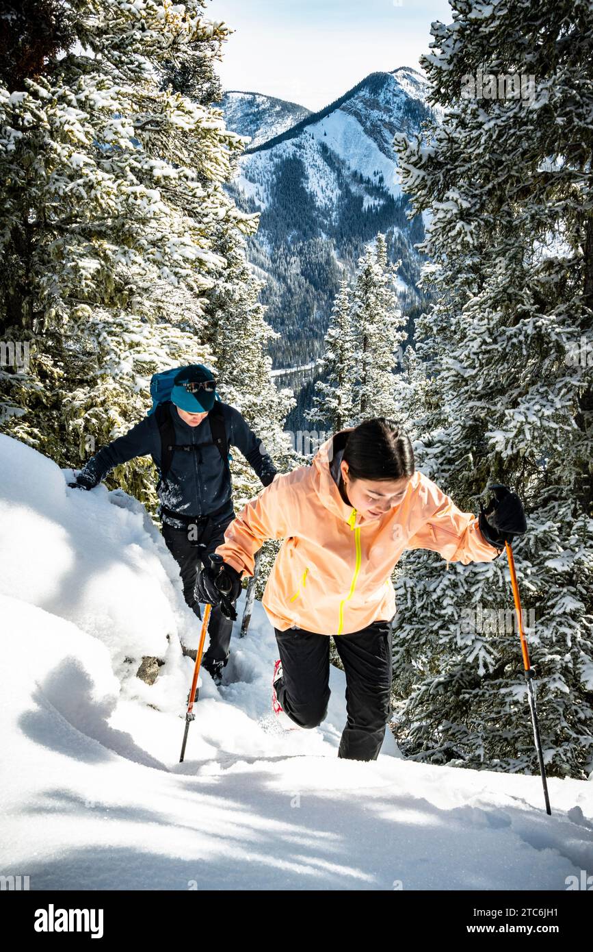 Dos amigos Masculino y Femenino escalan montaña en invierno Foto de stock