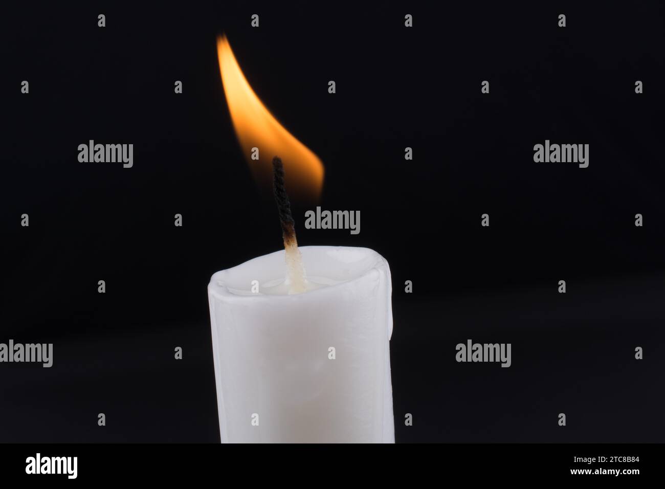 Cuatro velas blancas con una mecha encendida sobre una mesa
