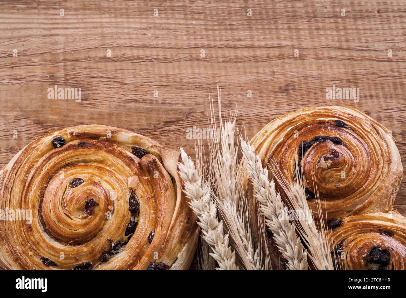 Orejas de trigo dorado raisin panadería en el concepto de comida y bebida de madera de roble Foto de stock
