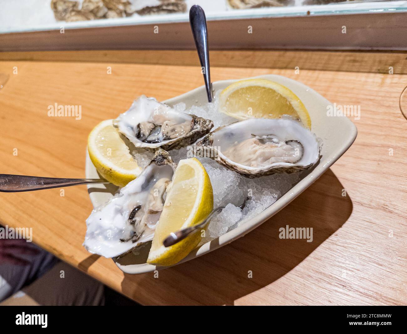 Deliciosas ostras crudas en la mitad de la concha en un restaurante Foto de stock