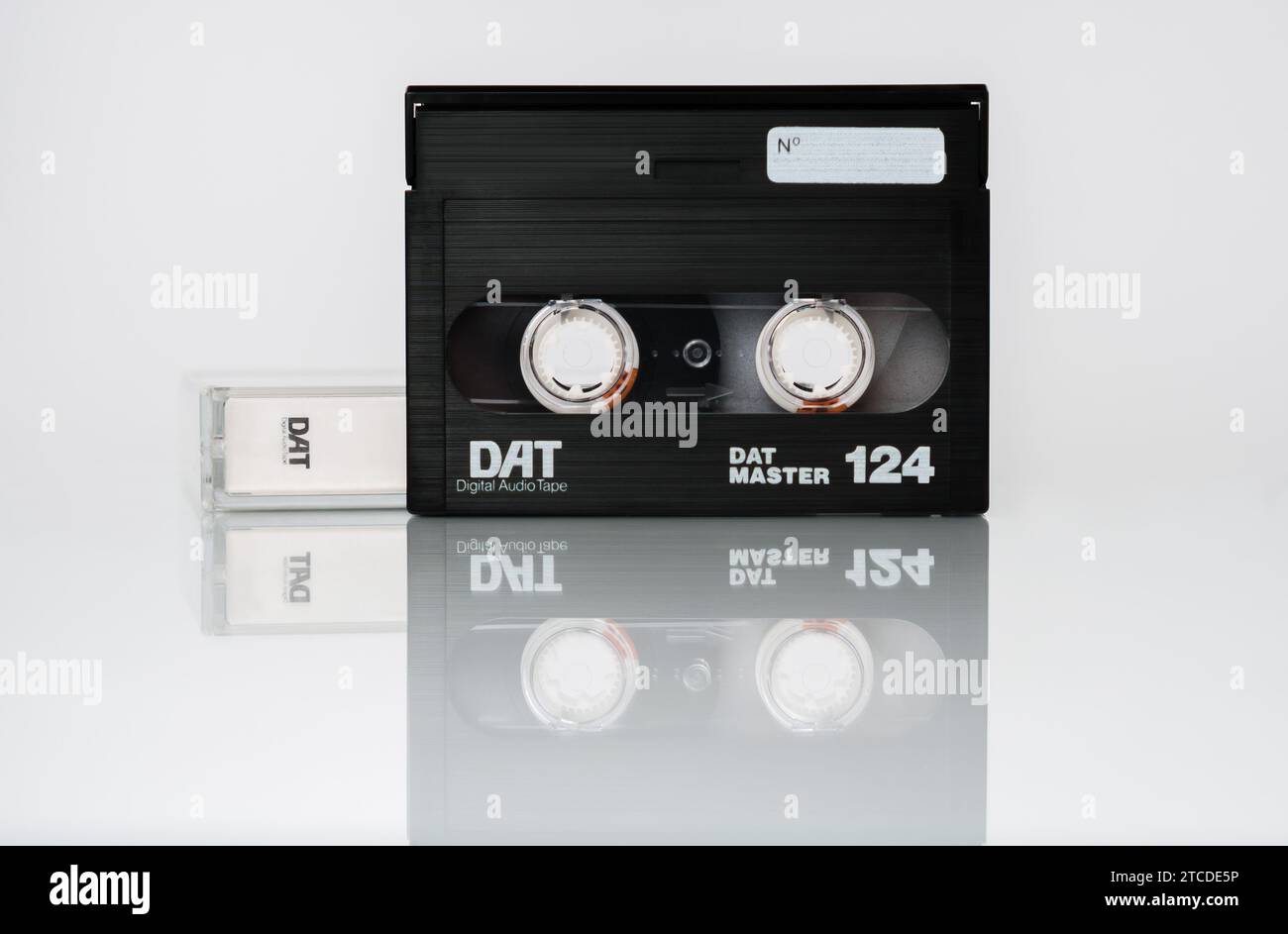 Vista frontal de un casete DAT (cinta de audio digital) con caja aislada sobre fondo blanco con reflexión Foto de stock