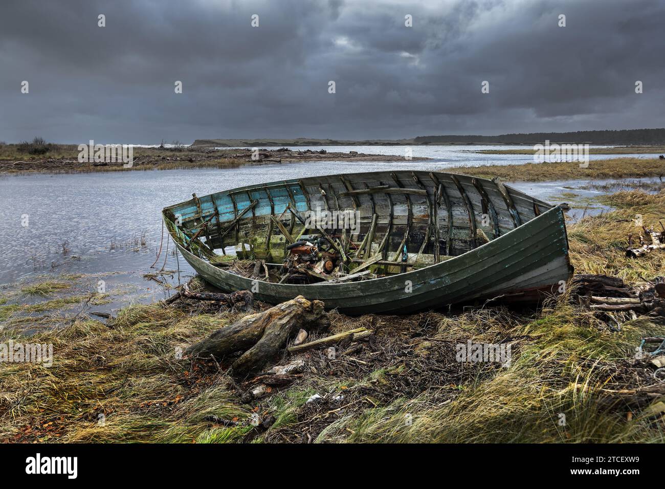 Un barco de pesca de madera abandonado en las dunas de arena en el estuario del río Esk, St Cyrus, Aberdeenshire, Escocia Foto de stock