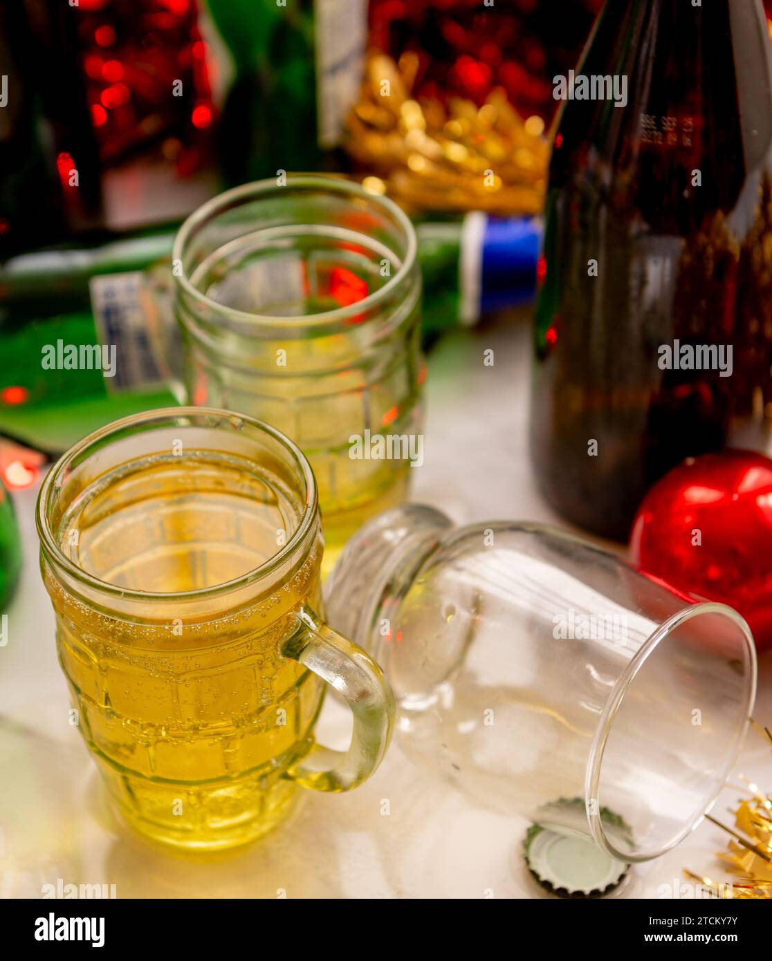 Un concepto festivo de celebración navideña con vasos y botellas de bebidas alcohólicas y decoraciones en una mesa. Foto de stock