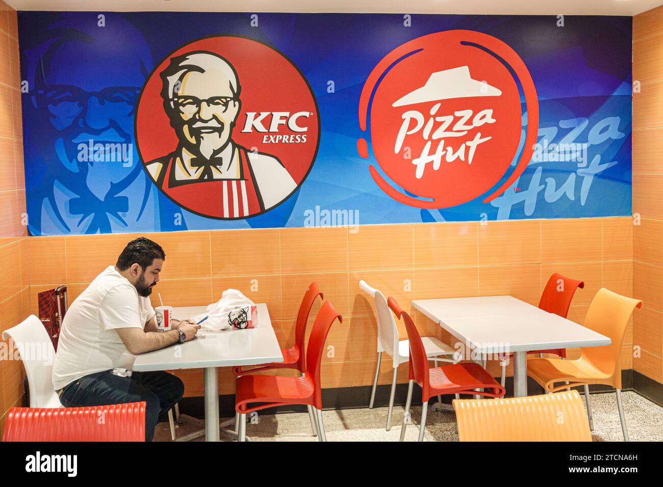 Miami Florida,Miami Aeropuerto Internacional MIA,interior interior interior,terminal de entrada,viajeros,KFC Kentucky Fried Chicken comida rápida,hombre Foto de stock