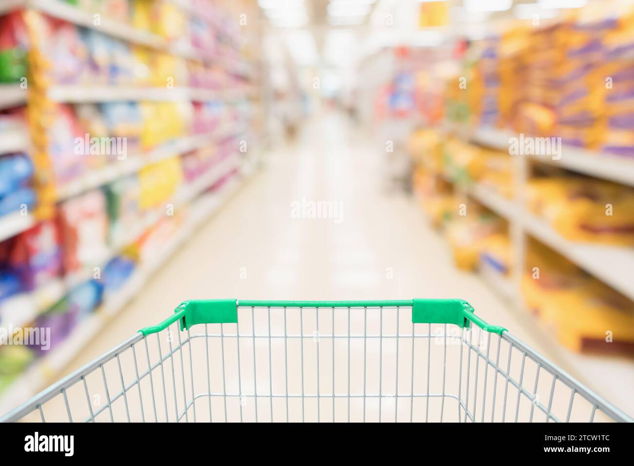 Carrito de la compra con desenfoque abstracto supermercado tienda de descuento pasillo y productos de comida para mascotas productos de alimentos interior fondo desenfocado Foto de stock