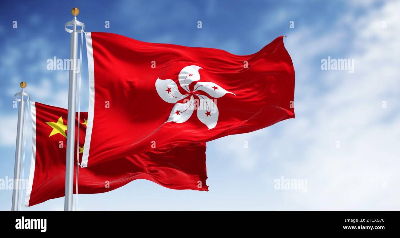 Banderas de Hong Kong y China ondeando en el viento en un día claro. Hong Kong es una ciudad y una región administrativa especial en China. Tela ondulada. SEL Foto de stock