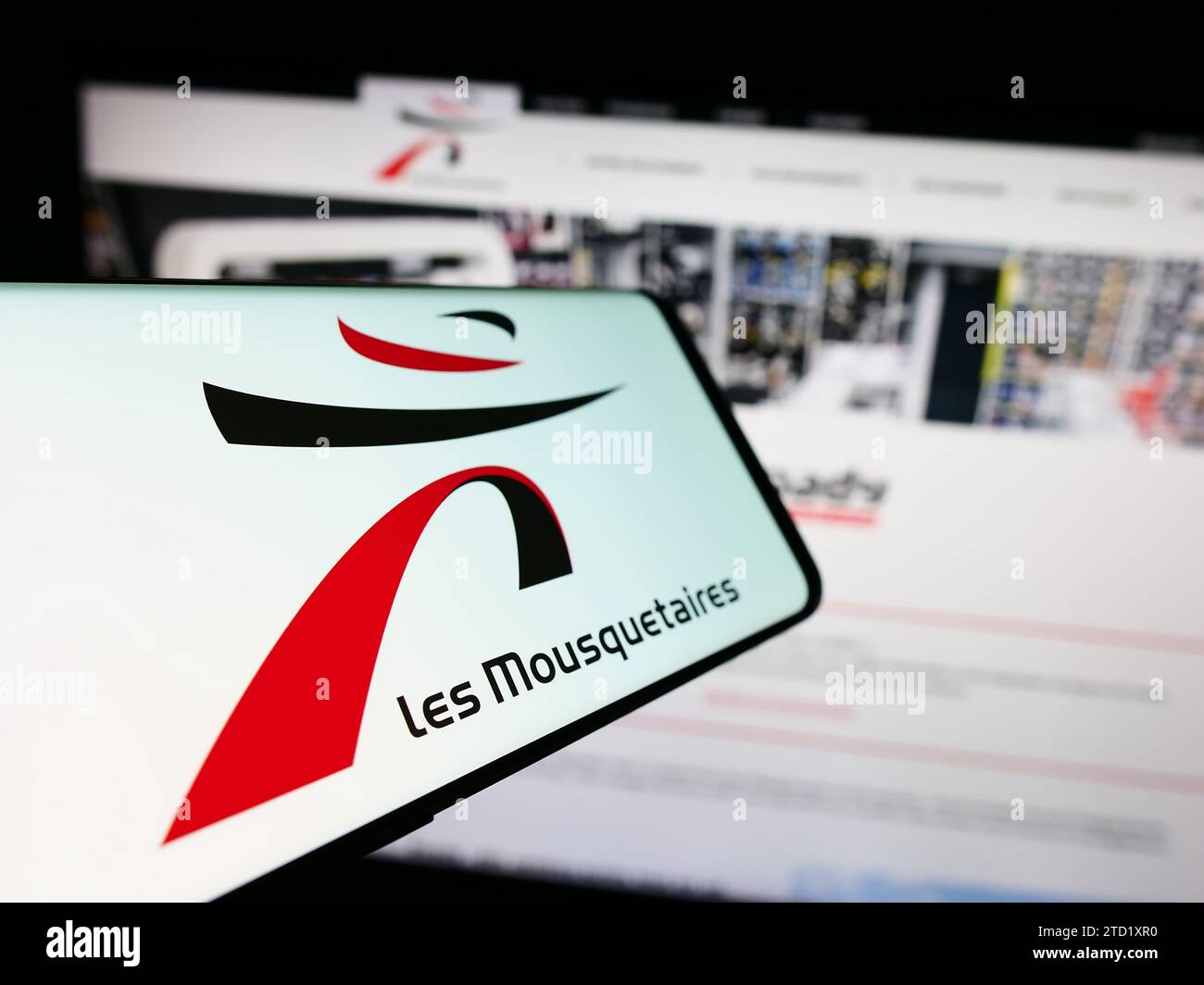 Smartphone con logo de la empresa francesa ITM Entreprises S.A. (Les Mousquetaires) delante del sitio web. Enfoque en centro-izquierda de la pantalla del teléfono. Foto de stock
