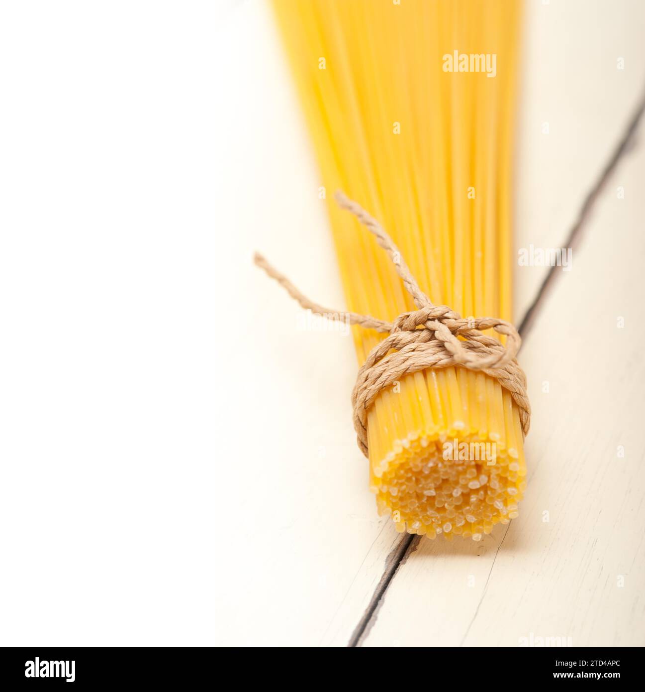 Las pastas italianas espaguetis atados con una cuerda en una tabla rústica Foto de stock