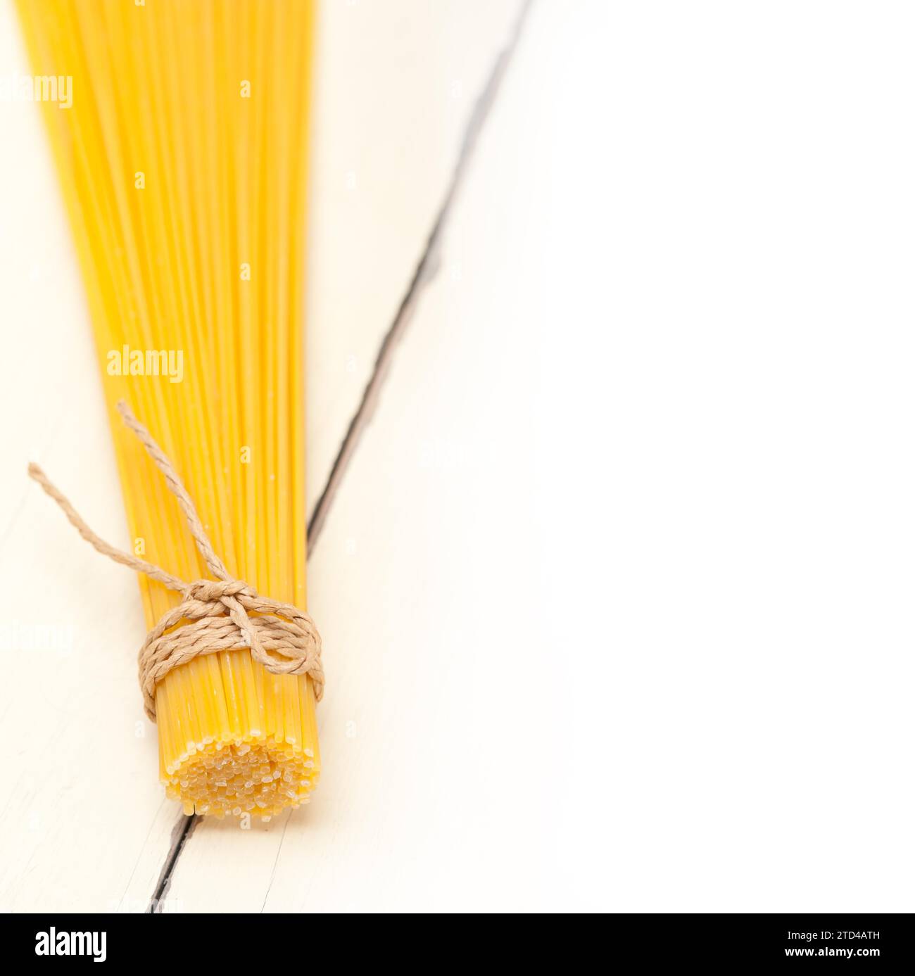 Las pastas italianas espaguetis atados con una cuerda en una tabla rústica Foto de stock