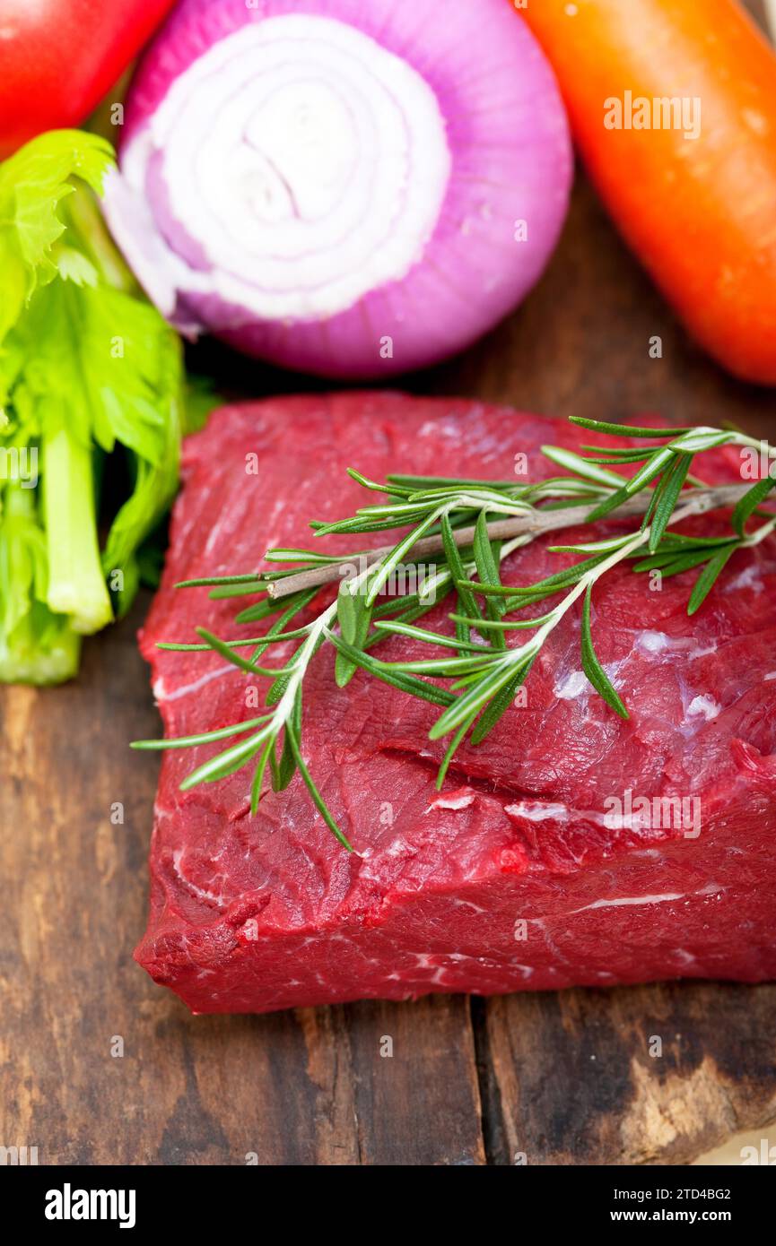 Carne fresca cruda cortada lista para cocinar con verduras y hierbas, fotografía de alimentos Foto de stock