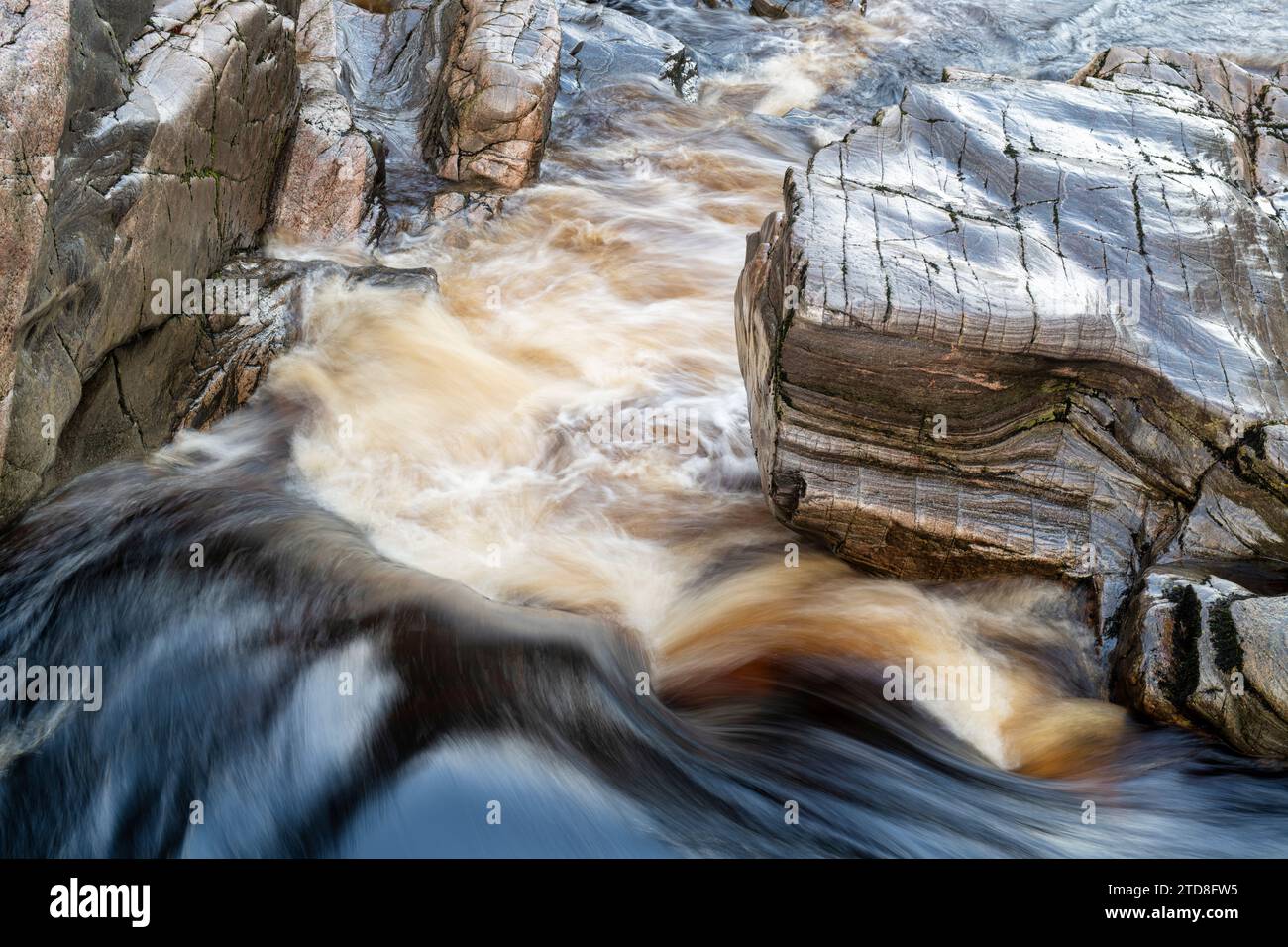 Agua que fluye rápidamente sobre las rocas. Randolf's Leap, River Findhorn, MORAYSHIRE, Escocia. Larga exposición abstracta Foto de stock