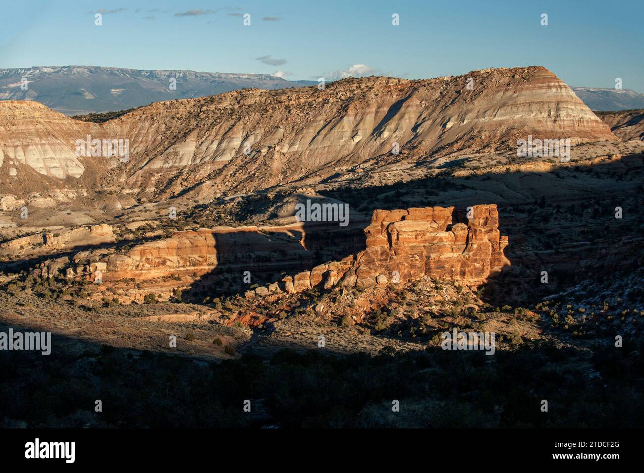 Los últimos rayos de sol del día iluminan la Cocina del Diablo del Monumento Nacional de Colorado, un remanente de arenisca de formación Wingate que descansa sobre el ciervo Foto de stock