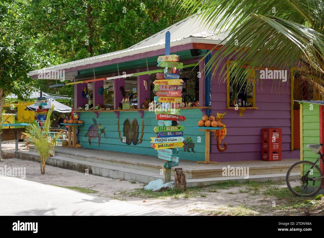 Colorida tienda de recuerdos de madera pintada para turistas en la playa de Anse Severe, la isla de La Digue, Seychelles, Océano Índico, África Foto de stock