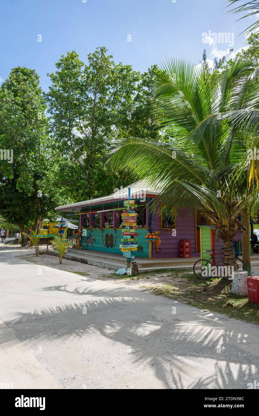 Colorida tienda de recuerdos de madera pintada para turistas en la playa de Anse Severe, la isla de La Digue, Seychelles, Océano Índico, África Foto de stock