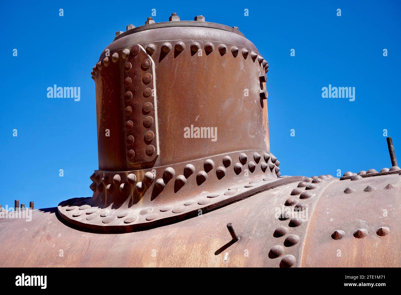Hierro oxidado en un tren de vapor abandonado bajo un cielo azul. Foto de stock