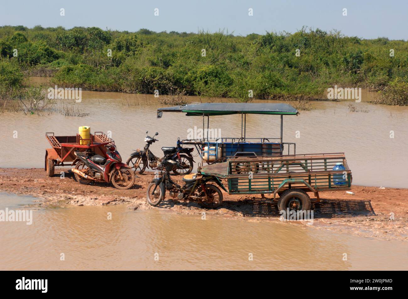 Bicicletas y remolques a la izquierda en mudflat, pueblo flotante Kampong Phluk en Tonle Sap Lake, Camboya, Asia. Foto de stock