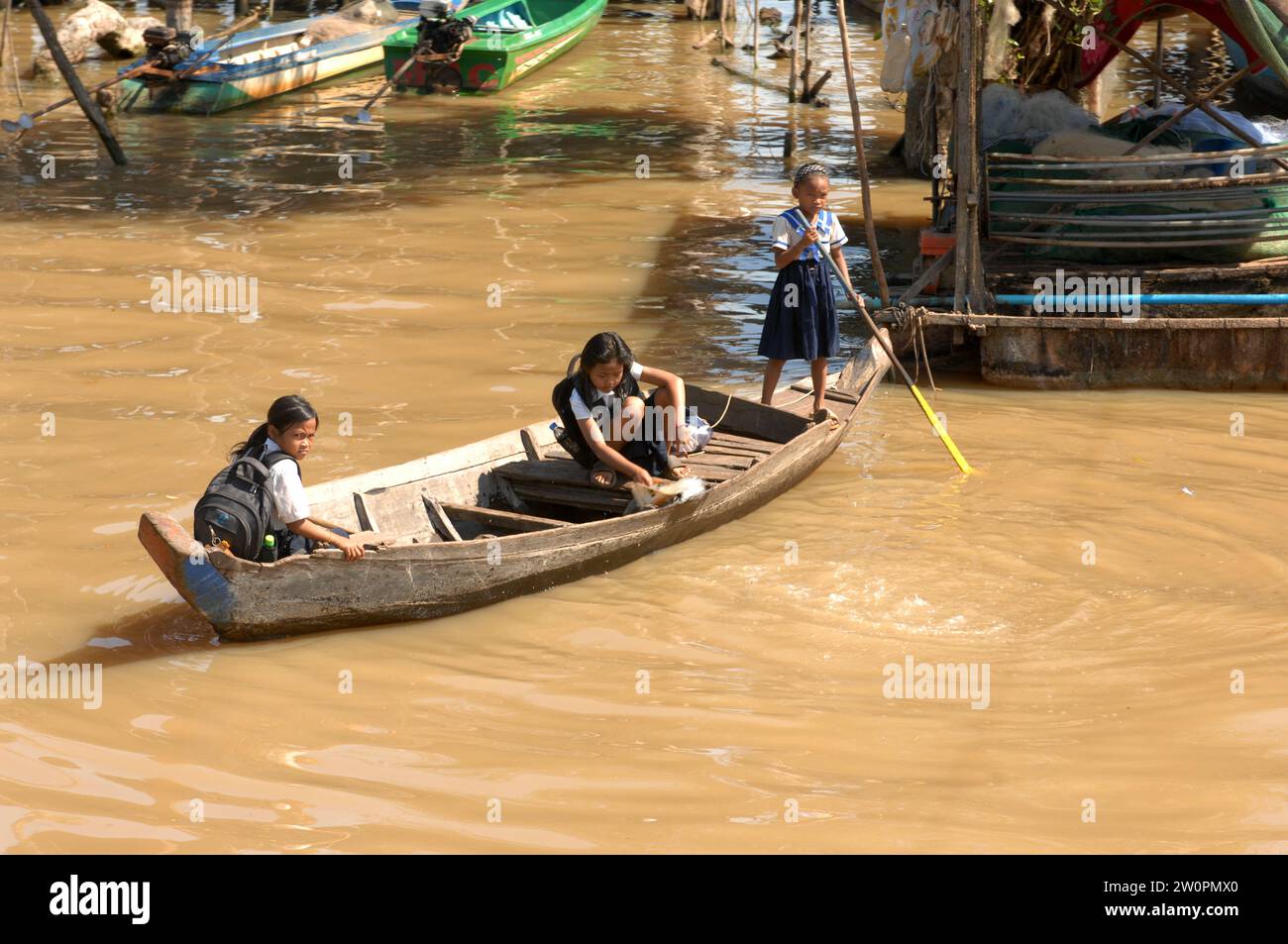 Tres niñas que van a la escuela en un barco, pueblo flotante Kampong Phluk en Tonle Sap Lake, Camboya. Foto de stock