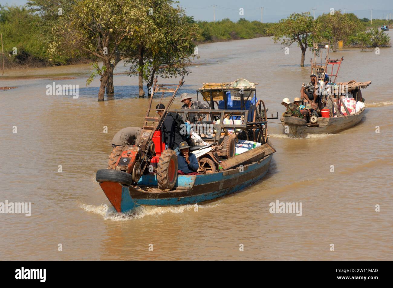 Trabajadores agrícolas que transportan maquinaria en barco, pueblo flotante Kampong Phluk en el lago Tonle Sap, Camboya, Asia. Foto de stock