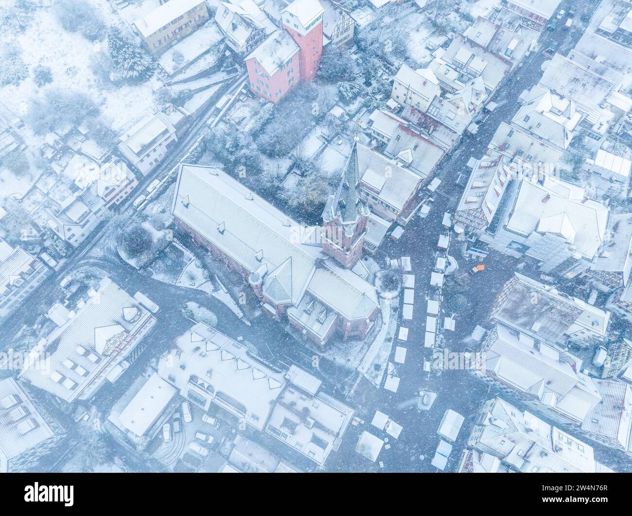 Imagen de dron de una ciudad cubierta de nieve con calles y techos visibles, Selva Negra, Calw, Alemania Foto de stock