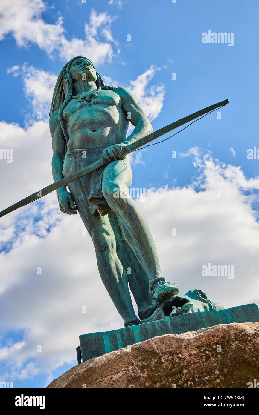 Majestuosa estatua del guerrero de bronce con lanza contra el cielo azul Foto de stock